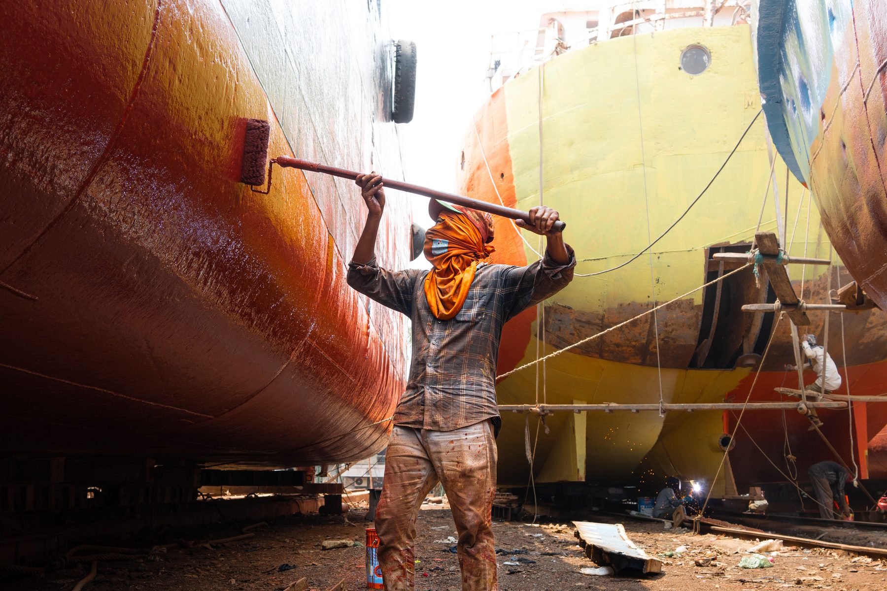 Workers maintaining and painting a vessel hull