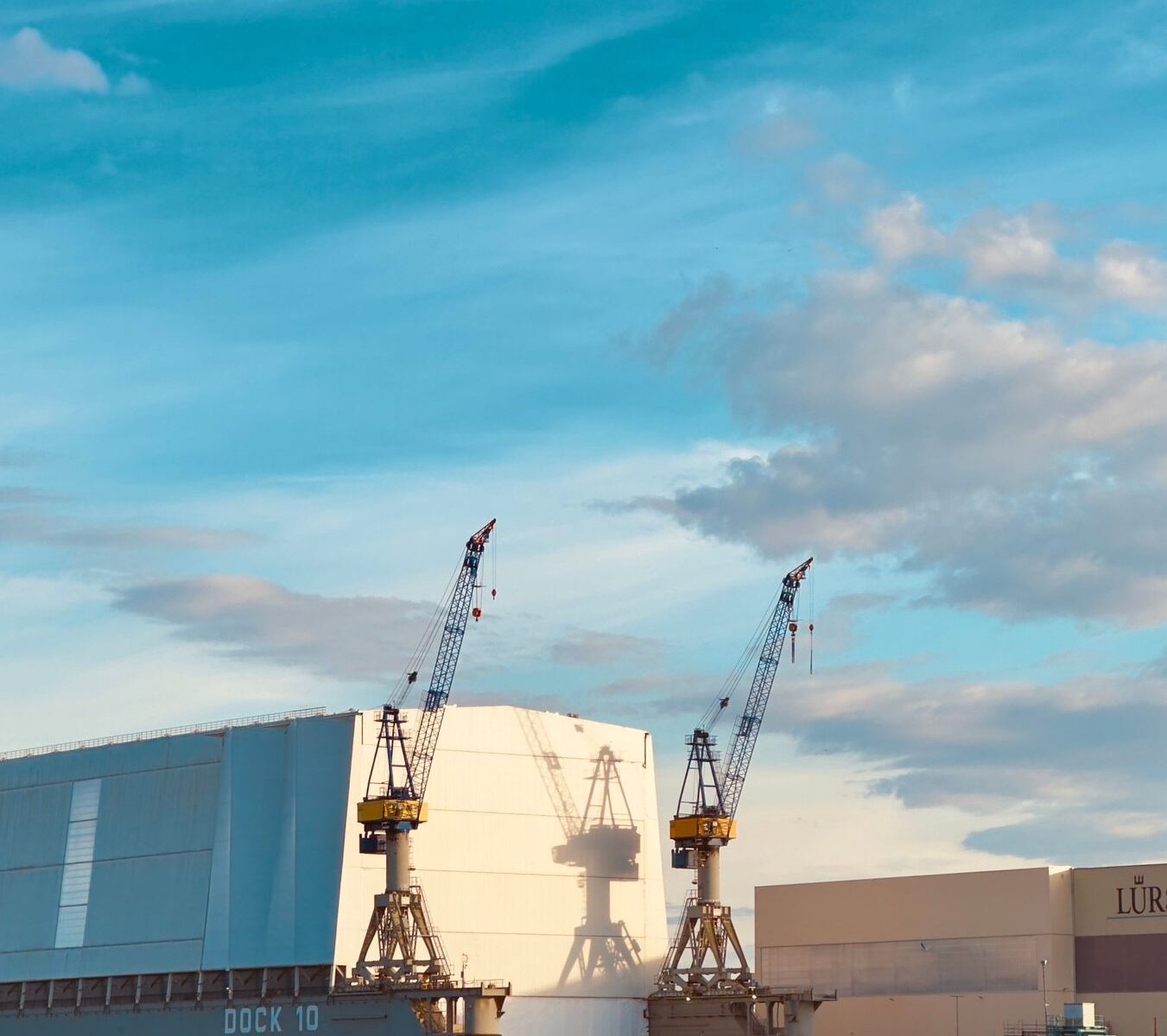 Shipyard cranes around a vessel under construction